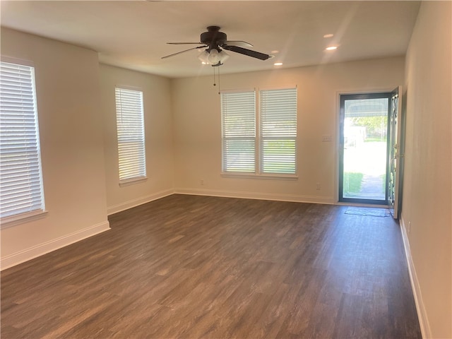 spare room with dark wood-type flooring and ceiling fan