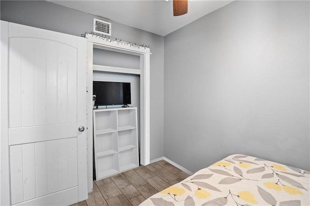 bedroom featuring hardwood / wood-style flooring, ceiling fan, and a closet