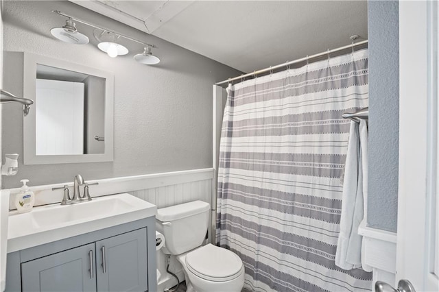 3938 Surfside Blvd Unit 3342, Corpus Christi, TX 78402 - full bathroom with vanity, a textured wall, a wainscoted wall, and a shower with curtain