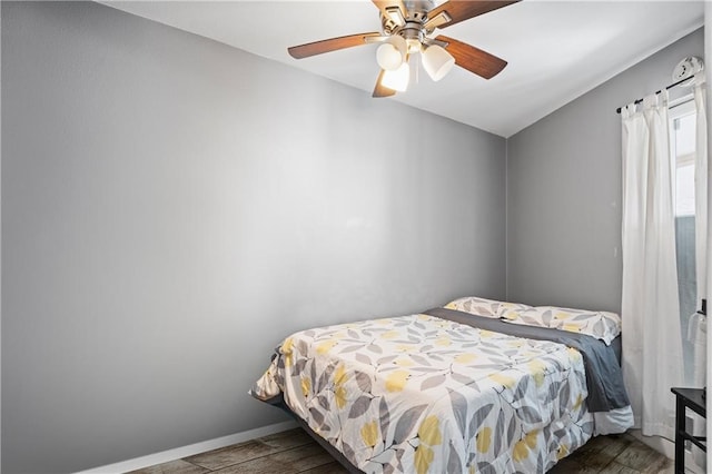 bedroom with dark wood-type flooring, lofted ceiling, and ceiling fan