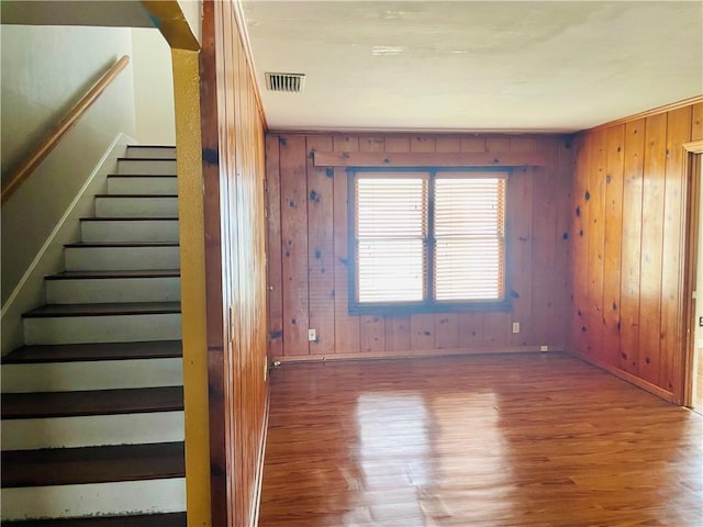 912 E Fulton St, Sinton, TX 78387 - stairs with wood finished floors, baseboards, and wood walls