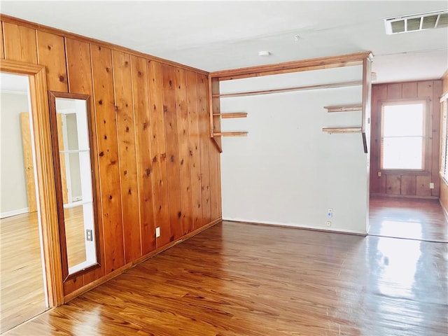 912 E Fulton St, Sinton, TX 78387 - spare room with light wood-style flooring, wooden walls, and baseboards