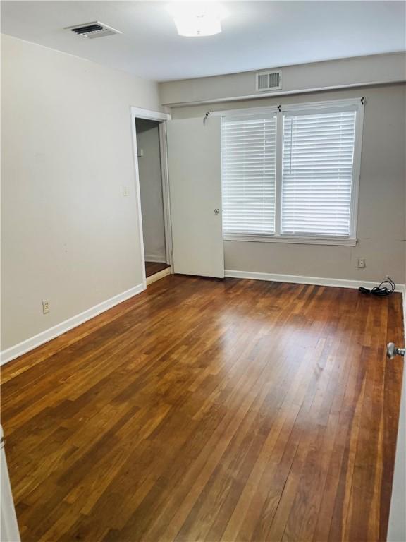 912 E Fulton St, Sinton, TX 78387 - empty room with wood-type flooring and baseboards
