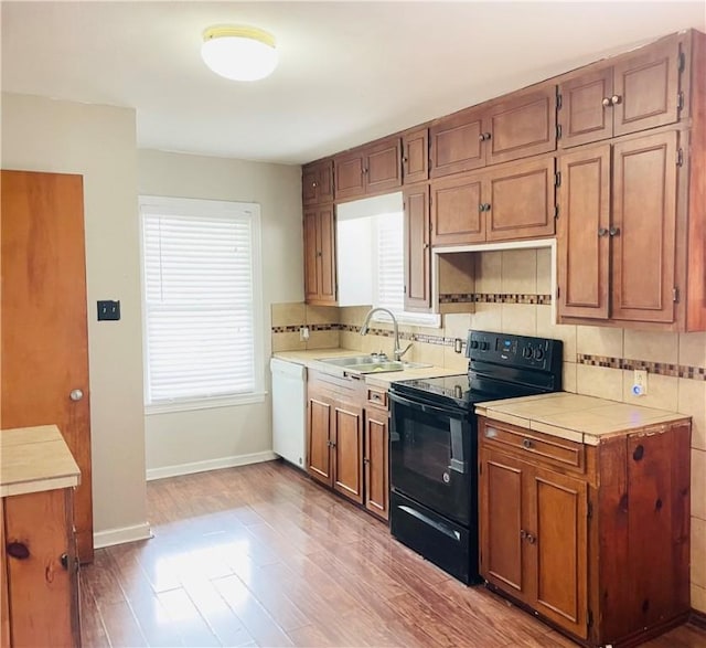 912 E Fulton St, Sinton, TX 78387 - kitchen with black range with electric cooktop, dishwasher, a sink, decorative backsplash, and baseboards