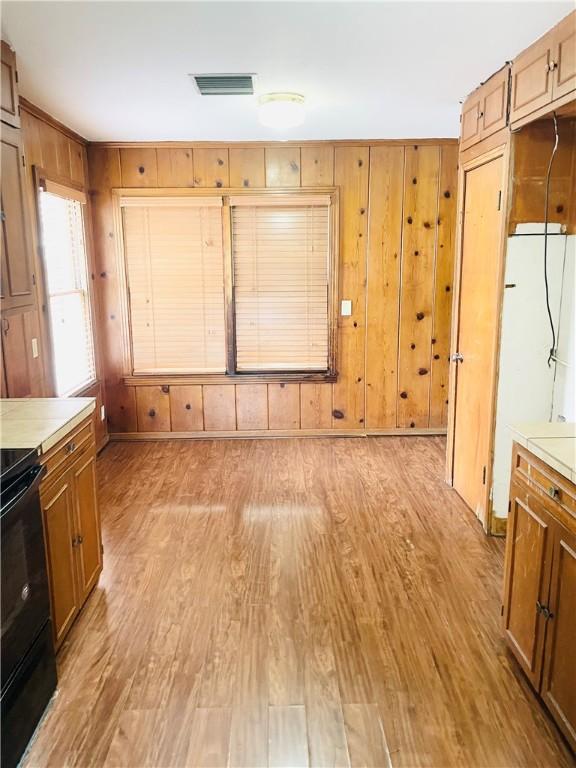 912 E Fulton St, Sinton, TX 78387 - unfurnished dining area with light wood finished floors and wooden walls