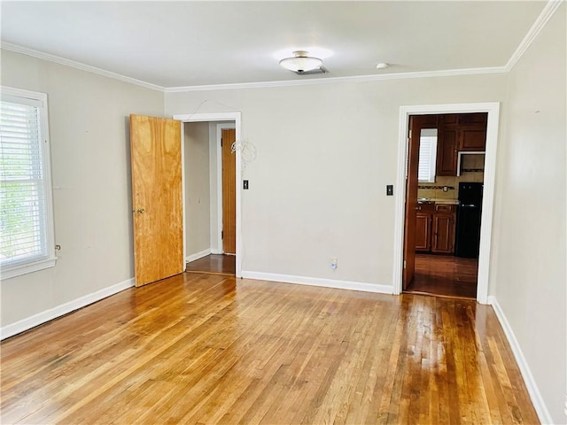 912 E Fulton St, Sinton, TX 78387 - empty room featuring light wood finished floors, ornamental molding, and baseboards
