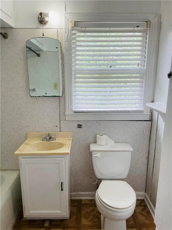 912 E Fulton St, Sinton, TX 78387 - bathroom with vanity, toilet, a tub, and baseboards