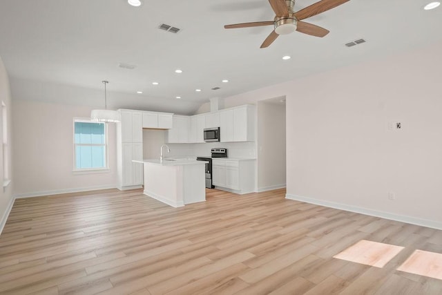 kitchen featuring sink, appliances with stainless steel finishes, white cabinetry, a center island with sink, and decorative light fixtures