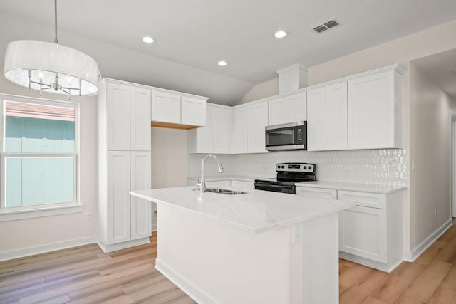 kitchen with stainless steel appliances, white cabinetry, sink, and a kitchen island with sink