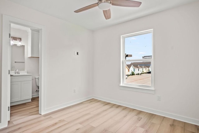 spare room with ceiling fan, sink, and light hardwood / wood-style floors