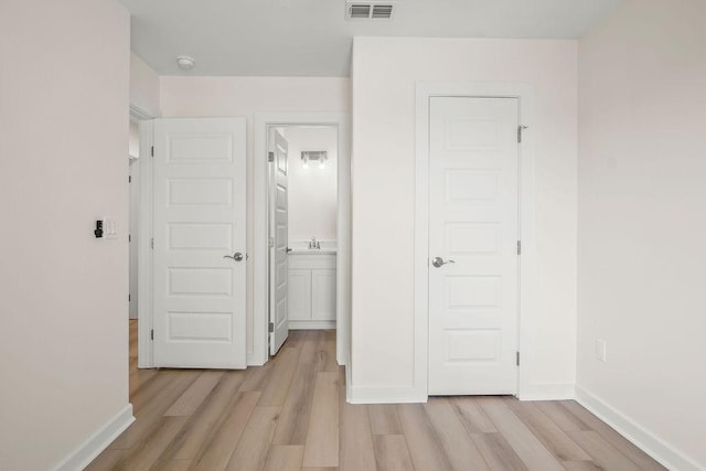 corridor with light hardwood / wood-style floors