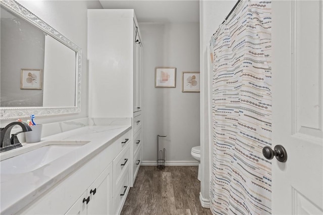 bathroom with toilet, vanity, and hardwood / wood-style flooring