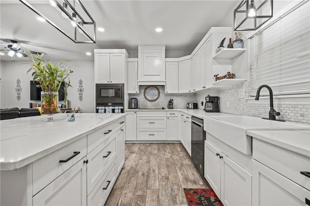 kitchen featuring black appliances, sink, white cabinets, and pendant lighting