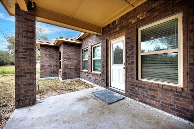 view of exterior entry with a patio