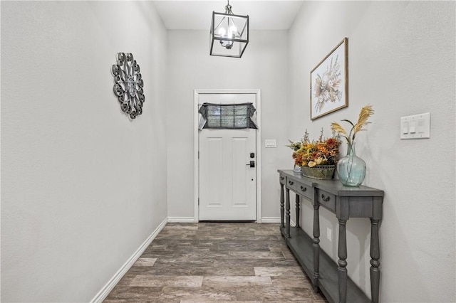 doorway to outside with dark hardwood / wood-style flooring and an inviting chandelier