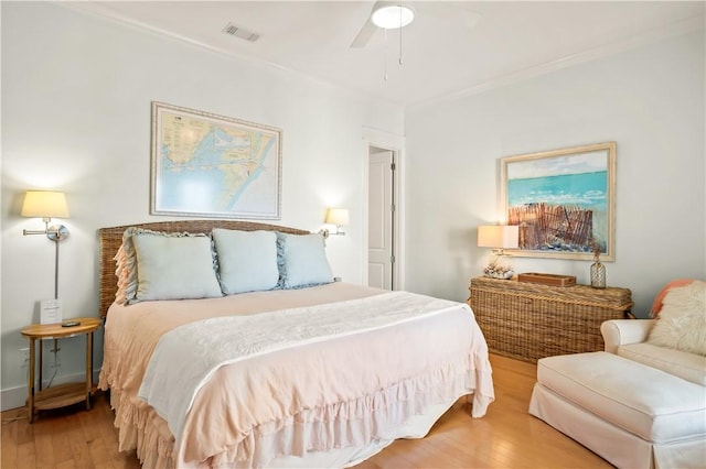 bedroom featuring ornamental molding, ceiling fan, and light wood-type flooring