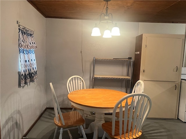 dining room with concrete flooring and a notable chandelier