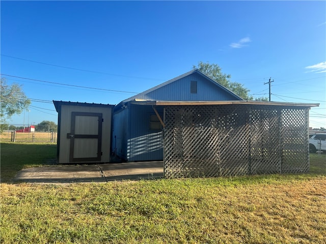 exterior space with a storage shed and a lawn