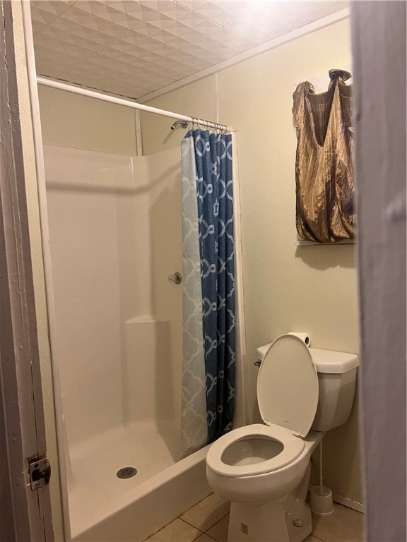 bathroom with walk in shower, tile patterned flooring, and toilet