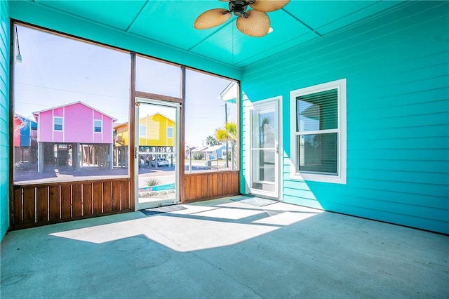 unfurnished sunroom with ceiling fan