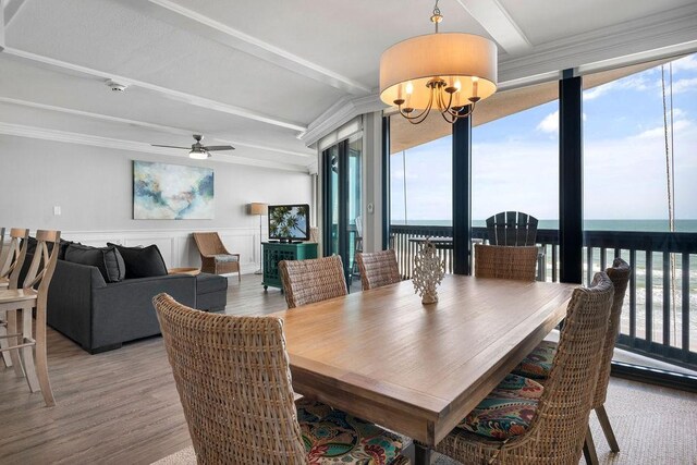 dining space featuring beamed ceiling, plenty of natural light, and wood finished floors