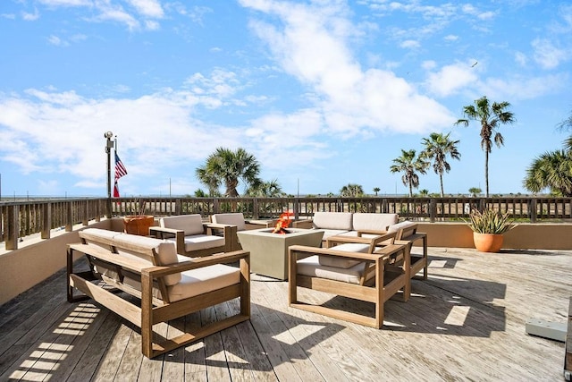 deck featuring an outdoor living space with a fire pit