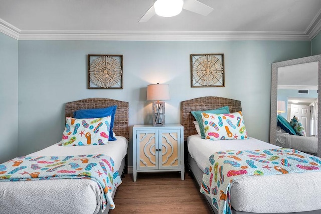 bedroom featuring visible vents, wood finished floors, a ceiling fan, and ornamental molding