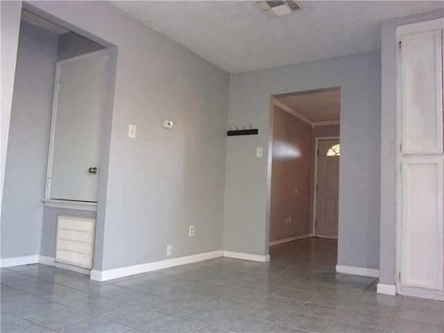 spare room with light tile patterned floors, visible vents, and baseboards