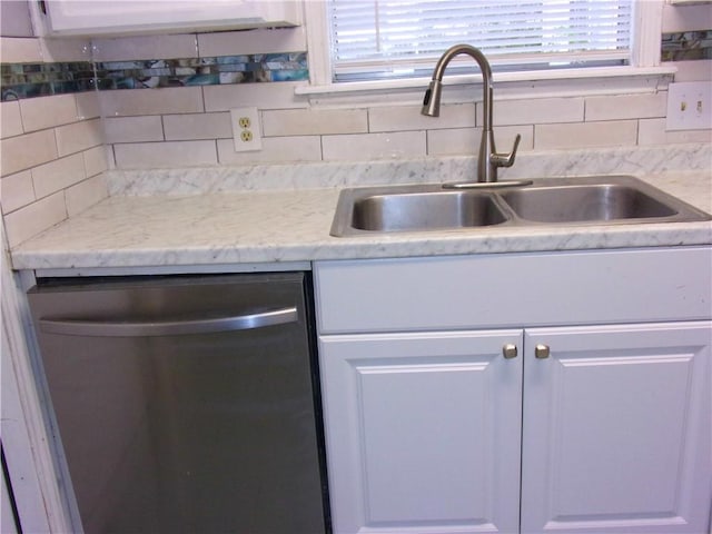 kitchen featuring tasteful backsplash, a sink, light countertops, and stainless steel dishwasher