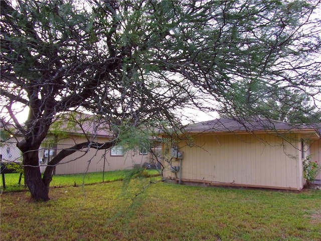 view of side of home with a yard