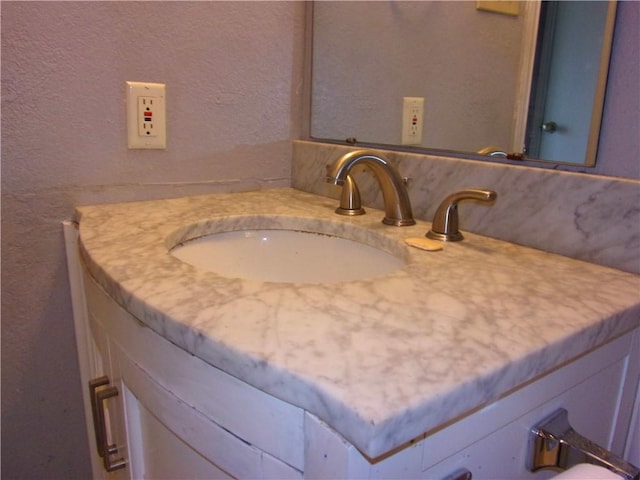 bathroom with vanity and a textured wall