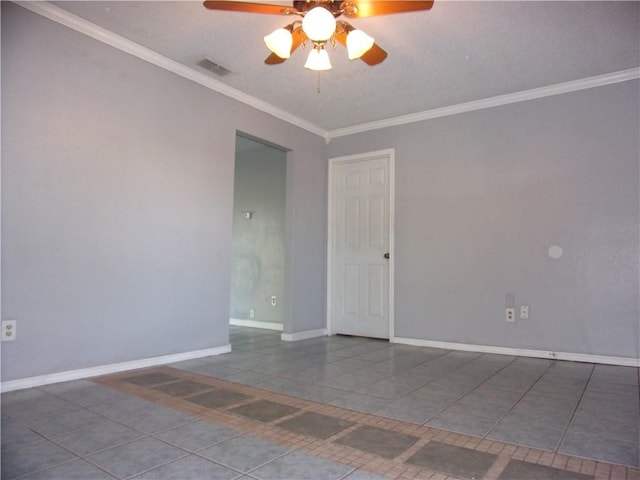 tiled empty room with visible vents, baseboards, ornamental molding, and a ceiling fan