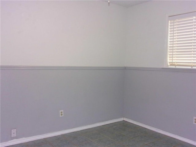 unfurnished room with dark tile patterned floors