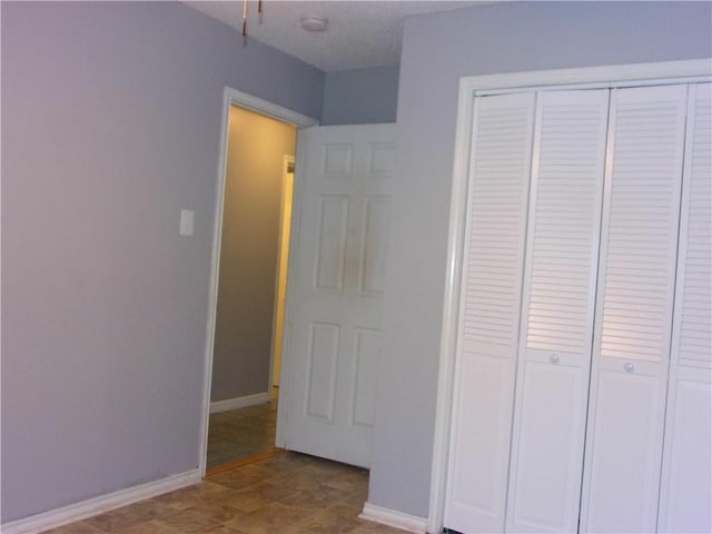 unfurnished bedroom with a closet and baseboards