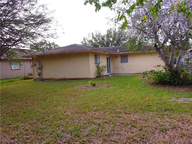 rear view of property with a yard