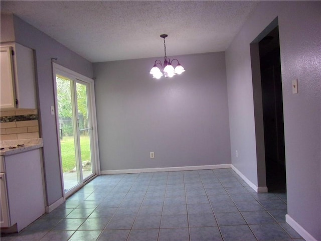 unfurnished dining area with light tile patterned flooring, a textured ceiling, and an inviting chandelier