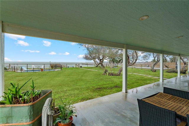 view of yard with a swimming pool, a patio area, and a water view