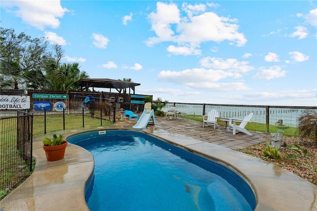 view of pool with a water view and a patio