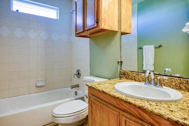 full bathroom with toilet, tiled shower / bath combo, and vanity