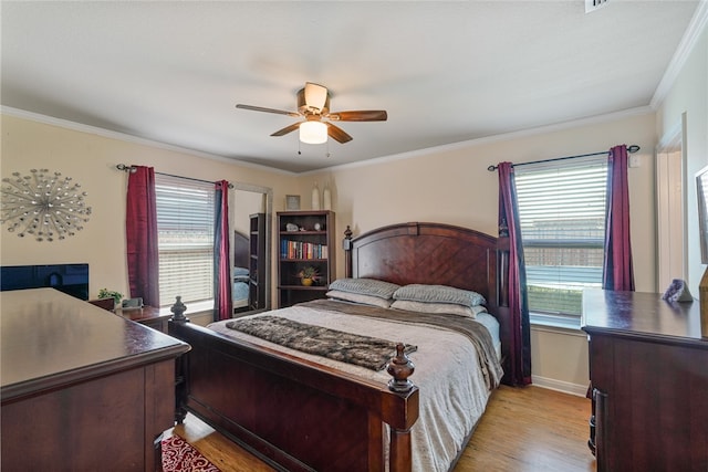 bedroom featuring ceiling fan, ornamental molding, and light wood-type flooring