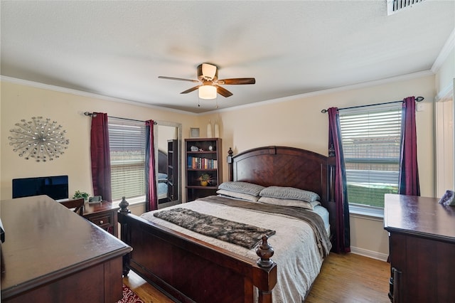 bedroom featuring light hardwood / wood-style floors, ceiling fan, and crown molding