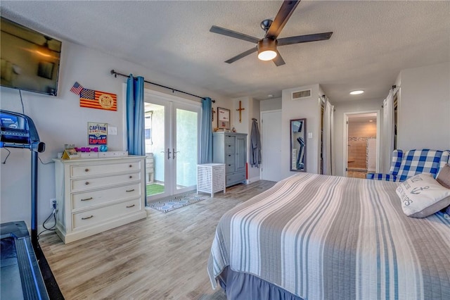 bedroom featuring french doors, a textured ceiling, light wood-type flooring, ceiling fan, and access to exterior