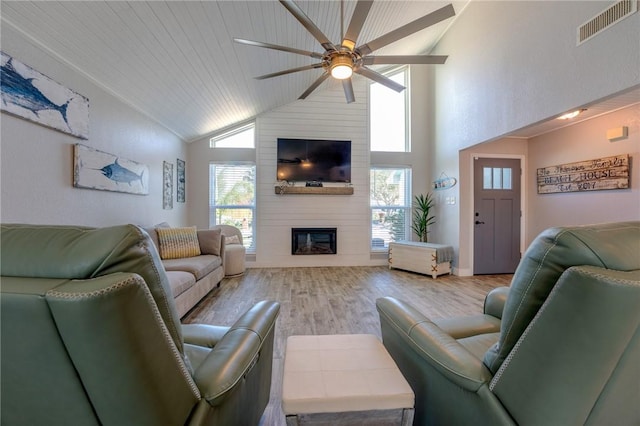 living room featuring high vaulted ceiling, a large fireplace, a wealth of natural light, and light hardwood / wood-style floors