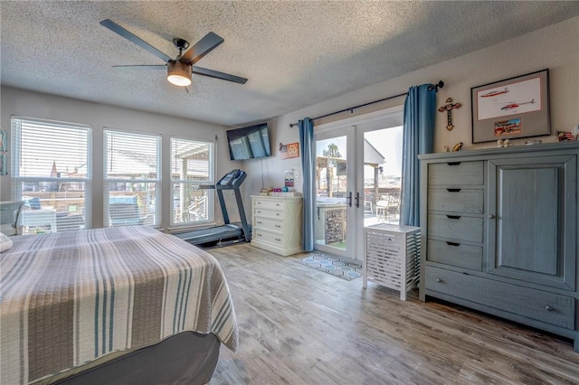 bedroom featuring french doors, access to exterior, multiple windows, and hardwood / wood-style flooring