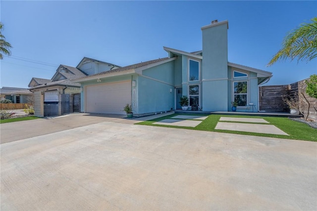 view of front facade with a garage, a chimney, concrete driveway, and stucco siding