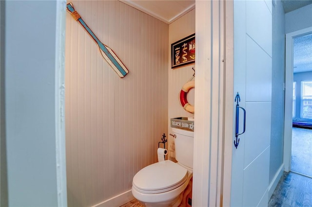 bathroom with hardwood / wood-style flooring and toilet