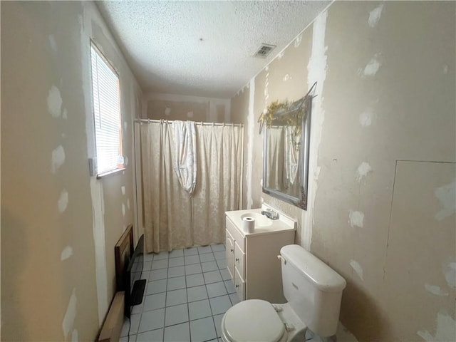 bathroom featuring tile patterned floors, walk in shower, a textured ceiling, vanity, and toilet