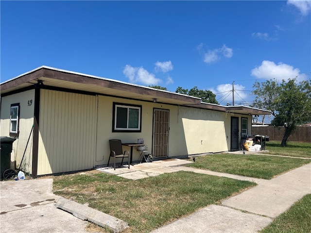 back of property with a lawn and a patio