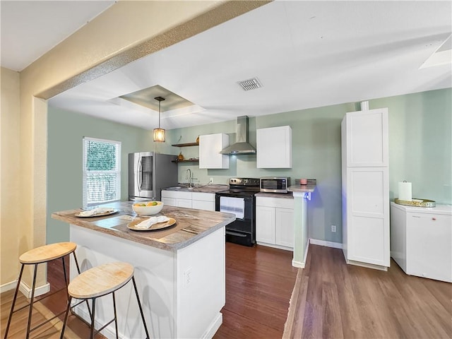 1205 Brentwood Dr, Corpus Christi, TX 78404 - kitchen with stainless steel appliances, wall chimney exhaust hood, a kitchen breakfast bar, dark wood finished floors, and white cabinetry