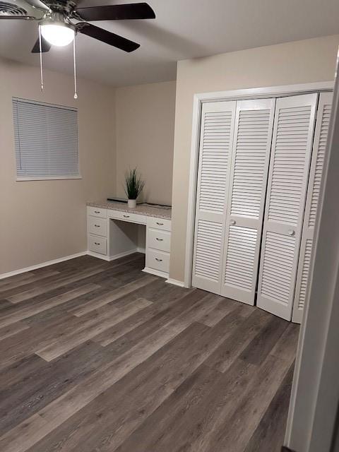 4633 Wilma Dr, Corpus Christi, TX 78412 - unfurnished office with dark wood-style floors, built in desk, baseboards, and ceiling fan